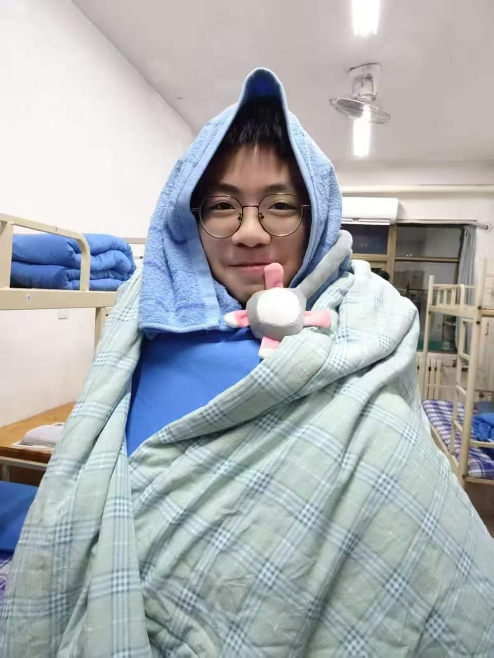 配泼睿裹着蓝色毛巾与格子毯